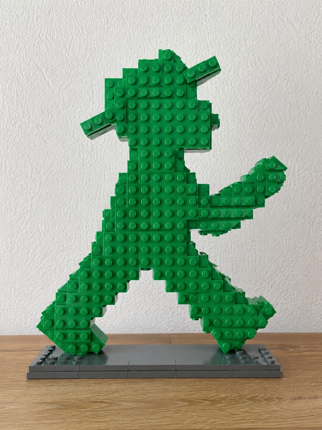 Klemmbaustein-Modell des Berliner Ampelmännchens in Grün auf grauer Grundplatte