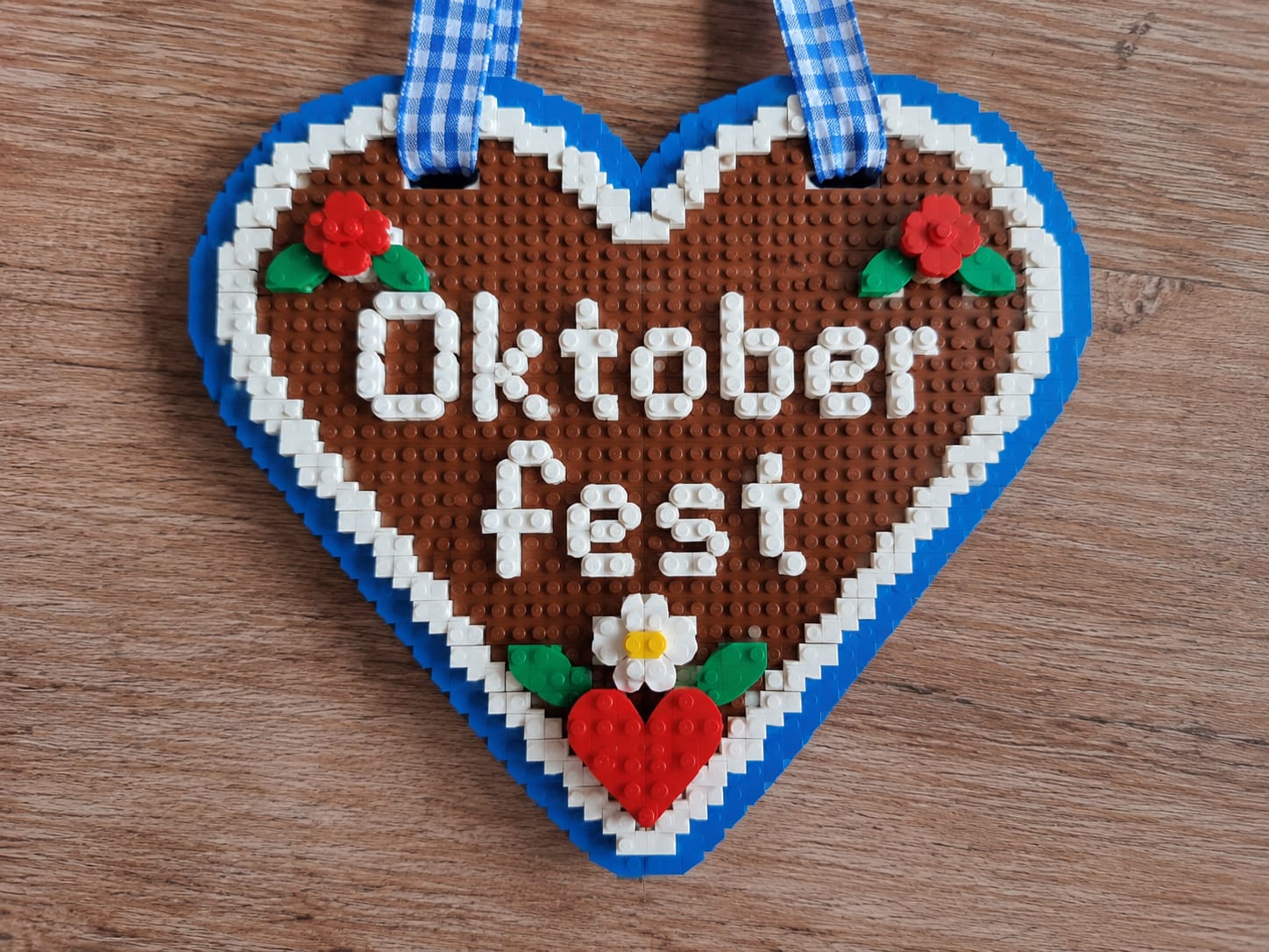 Lebkuchenherz aus Klemmbausteinen mit dem Schriftzug Oktoberfest und blau-weißem Band